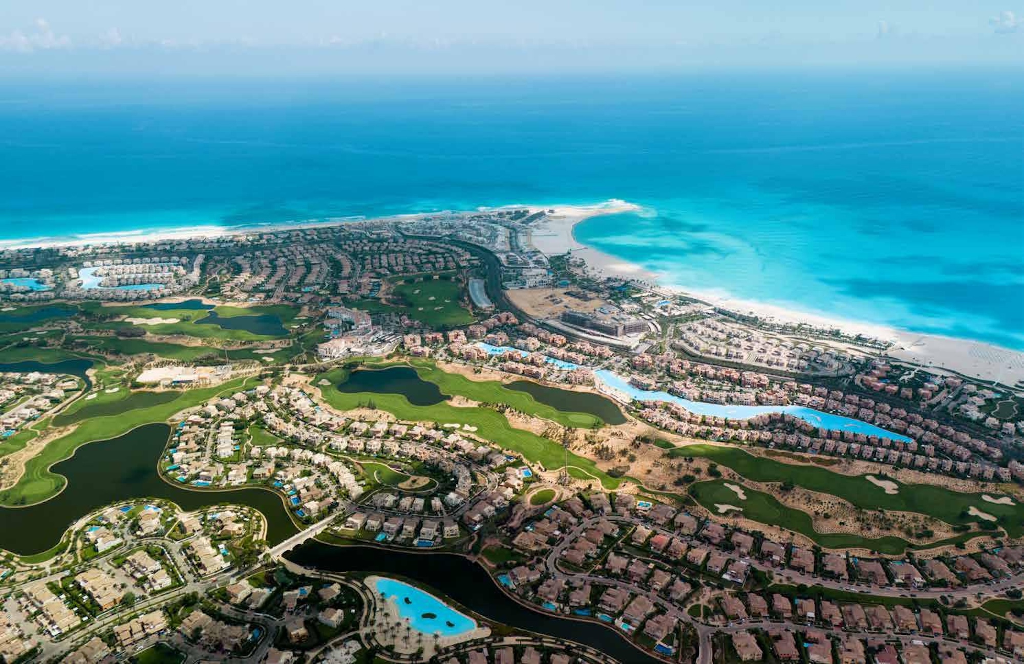 Luftfoto av Marassi i Egypt med golfbane, laguner og Middelhavet i bakgrunnen